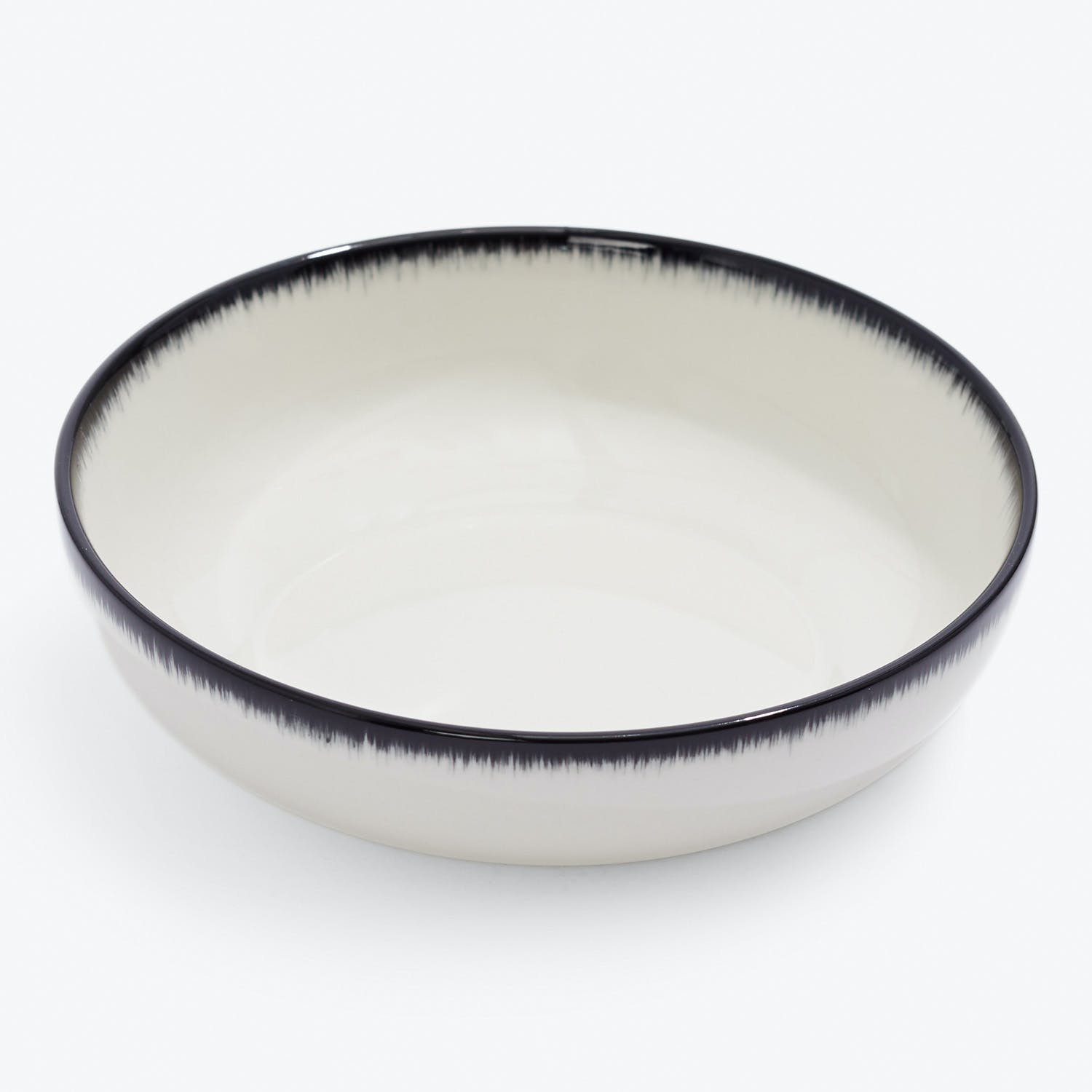 Minimalist ceramic bowl with handcrafted black border for versatile use.