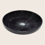 Black plate with unique starburst design, perfect for serving food
