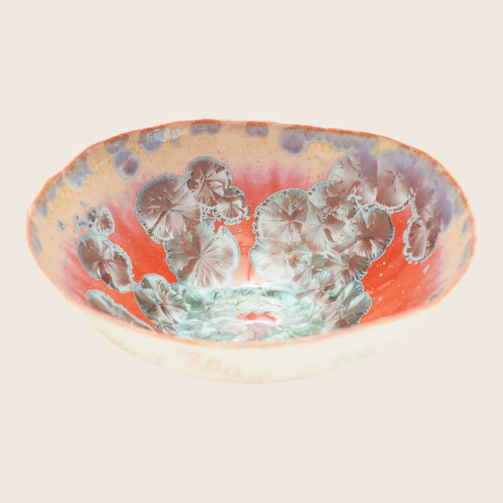 Handcrafted ceramic bowl with intricate floral pattern in vibrant colors.
