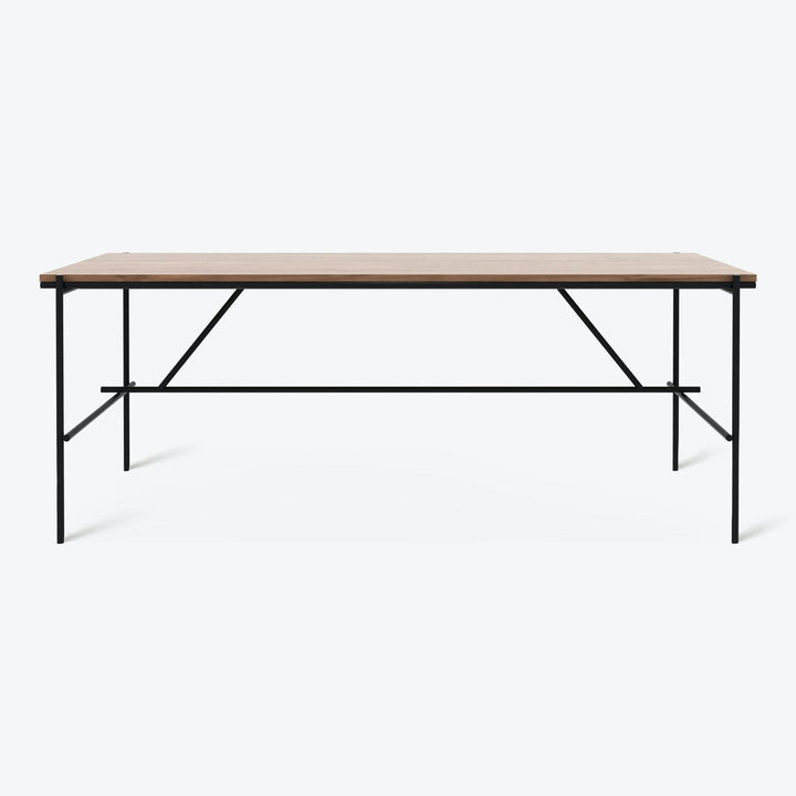 Modern and sleek rectangular table with light wood top and black metal frame and legs.