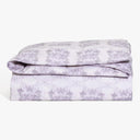 Neatly folded purple and white tie-dye comforter exuding abstract elegance.