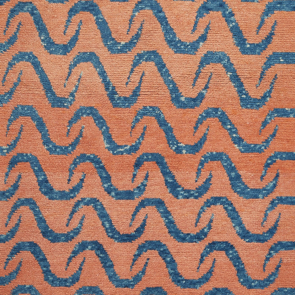 Close-up of textured textile with zigzag pattern in terracotta and blue.