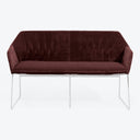 Luxurious burgundy velvet sofa with sleek chrome legs exudes elegance.
