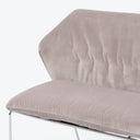 A modern chair with plush cushioning in pale pink velvet.