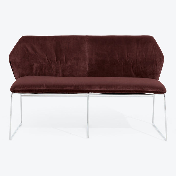 Modern burgundy velvet loveseat with sleek chrome-finished metal legs.