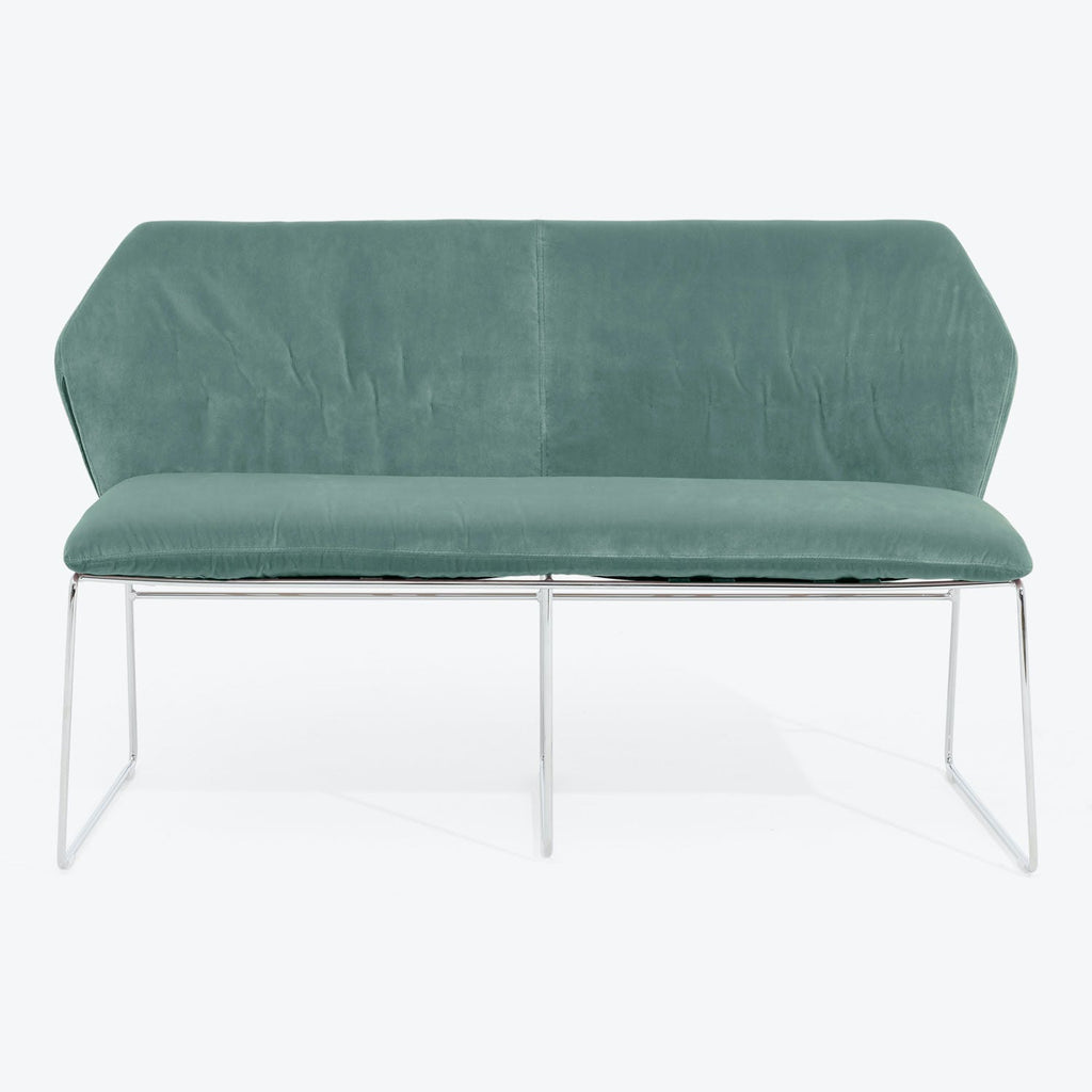 Elegant teal velvet sofa with sleek chrome frame for modern spaces.