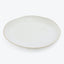 Simple and elegant off-white ceramic plate with a subtle rim.