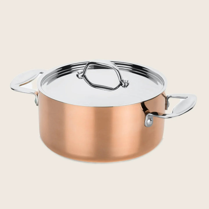 A polished copper pot with silver lid for efficient cooking.