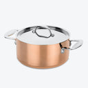 A polished copper pot with silver lid for efficient cooking.