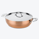 A shiny copper sauté pan with a silver lid and handles.