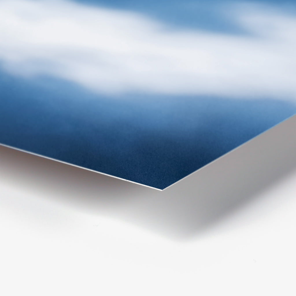 Close-up of white paper with curled edge, ombre blue gradient.