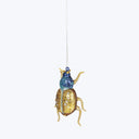 Festive beetle ornament with glitter and jewel embellishments hanging decoratively.