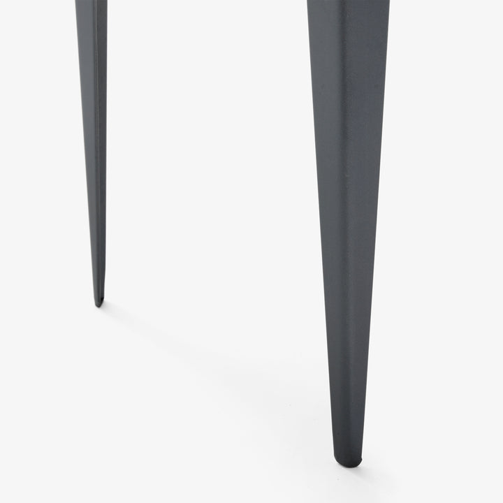 Close-up of black tapered furniture legs on white background.