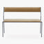Contemporary steel bench with upholstered tan fabric, minimalist design.