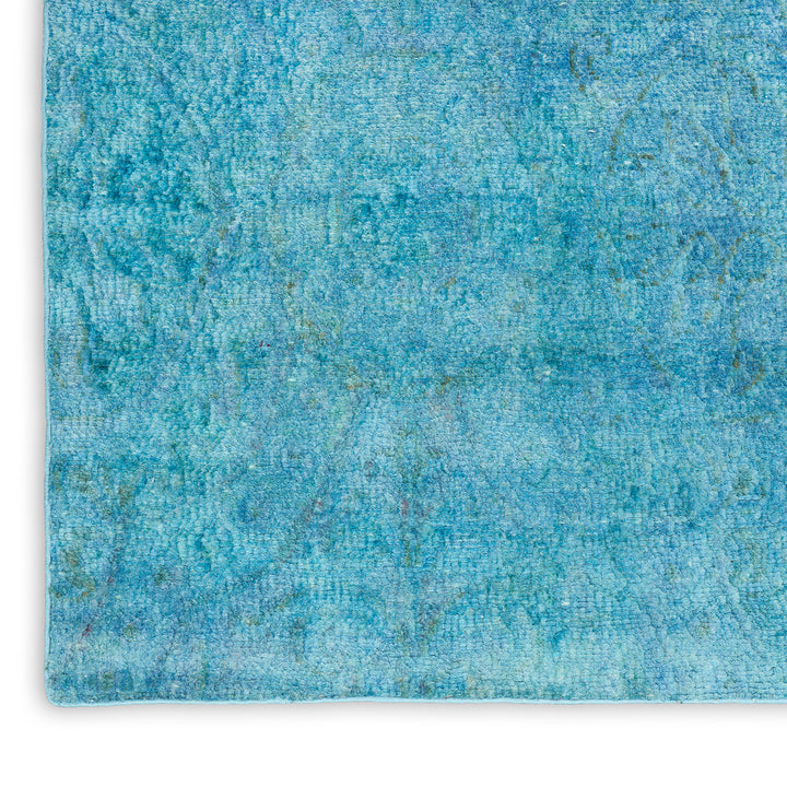Textured blue fabric with irregular nubby pattern and faded designs.