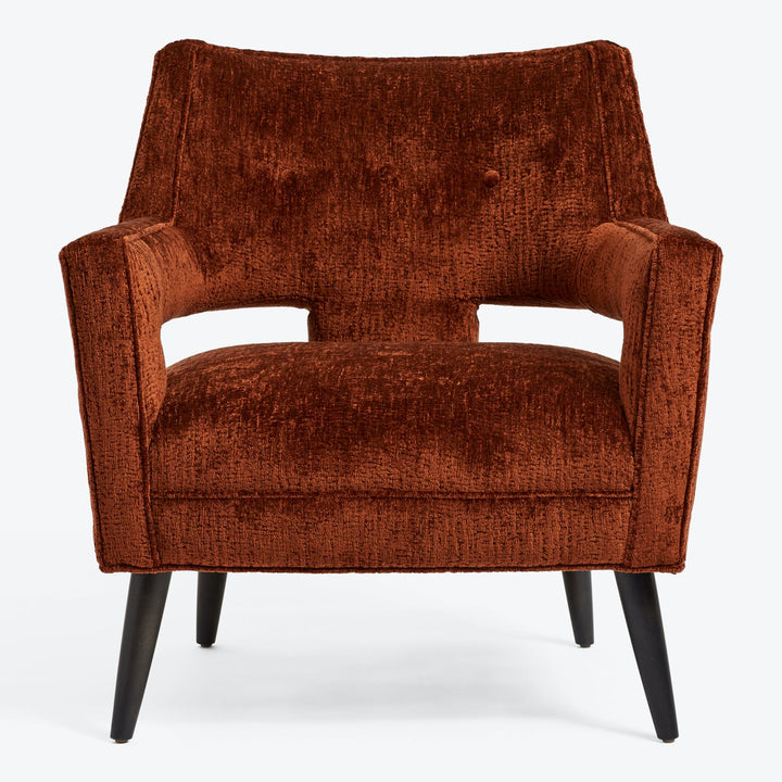 Modern armchair in burnt orange adds warmth to any space.