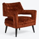 Contemporary armchair with plush rust-colored upholstery and button tufting.