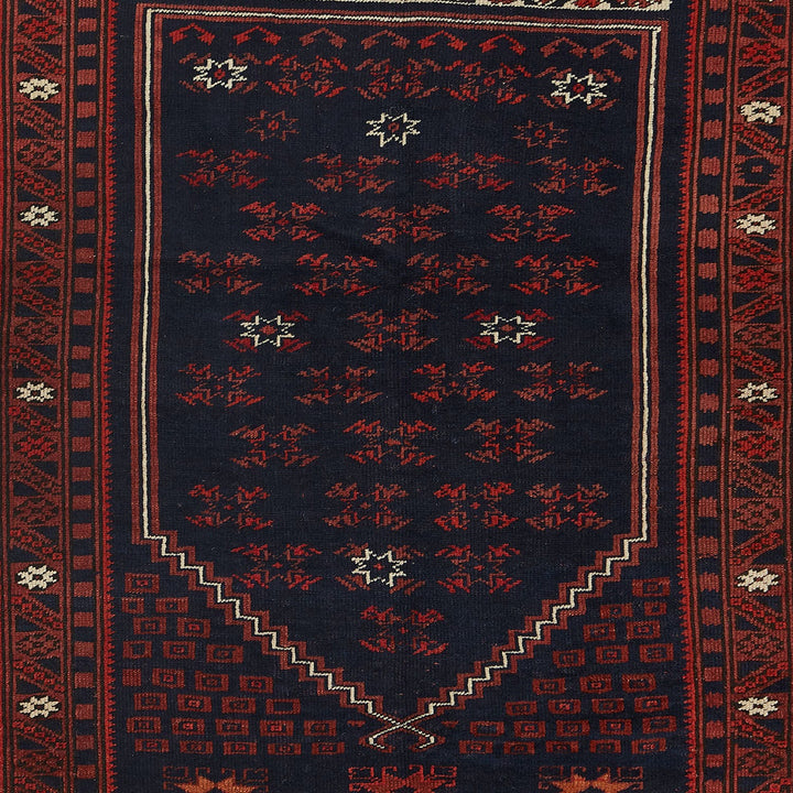 Traditional handwoven rug with intricate patterns in navy and red