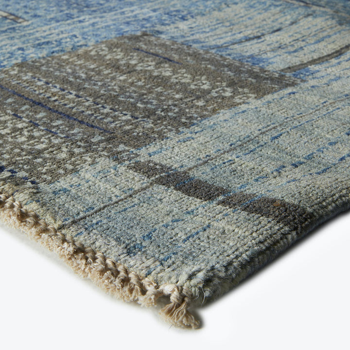 Close-up of a textured blue rug with geometric design.