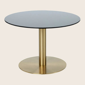Contemporary round table with black top and golden pedestal stand.