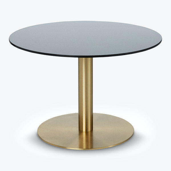 Contemporary round table with black top and golden pedestal stand.