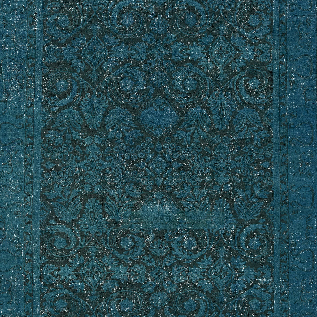 Elaborate teal blue fabric with ornate symmetrical pattern and metallic sheen.