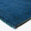 Close-up of a durable, hand-woven deep blue rug with fringe.