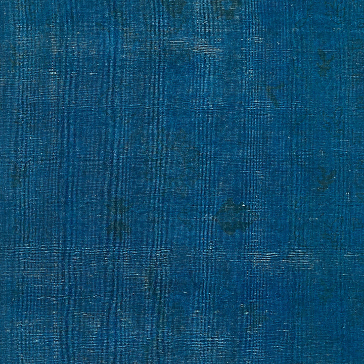 Textured, deep blue fabric with faded areas resembling denim crisscross pattern.