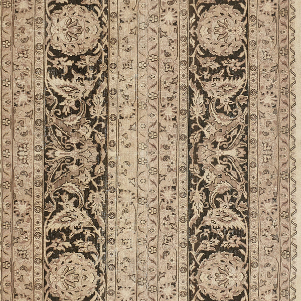 Close-up of an intricately patterned, symmetrical carpet with muted colors.