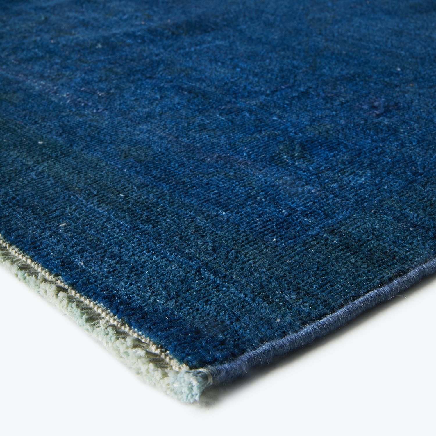 Close-up of a high-quality deep blue rug with looped texture.