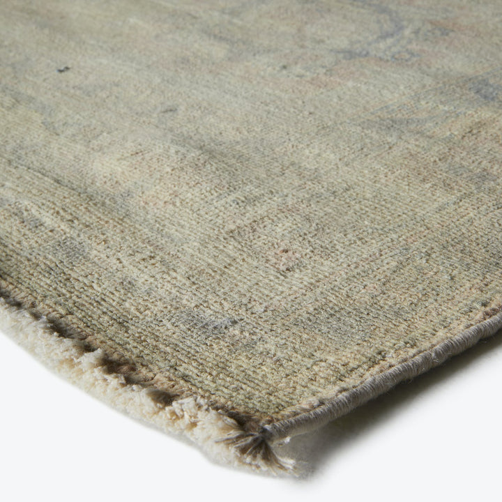 Close-up of a worn textile displaying frayed edges and mottled color.