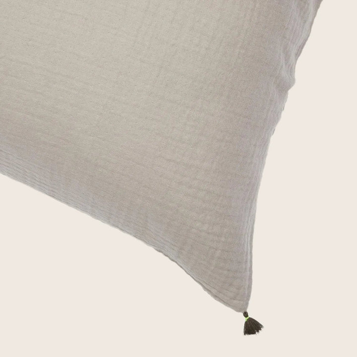 Close-up of textured cushion with black tassel adds subtle detail.