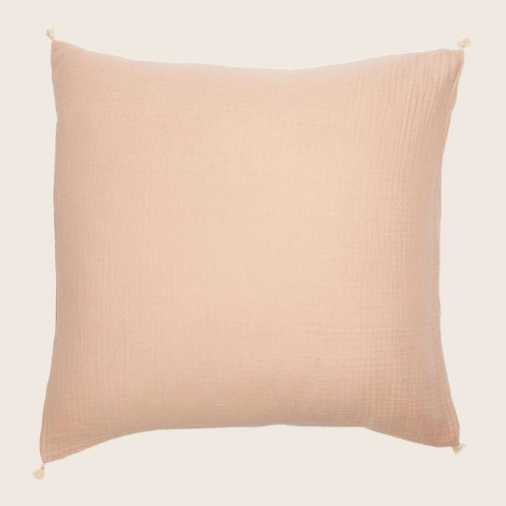 Square pillow in light peach with textured waffle weave fabric.