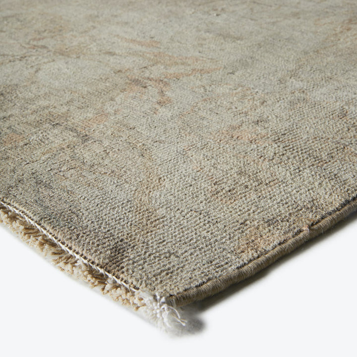 Muted tones and intricate patterns showcase a distressed, flat-weave rug.