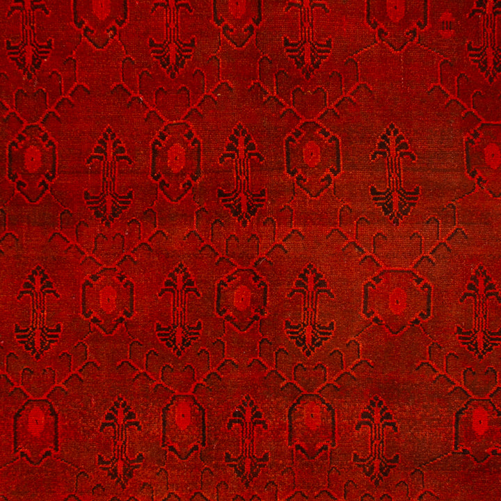 Close-up of rich red fabric with intricate symmetrical pattern.
