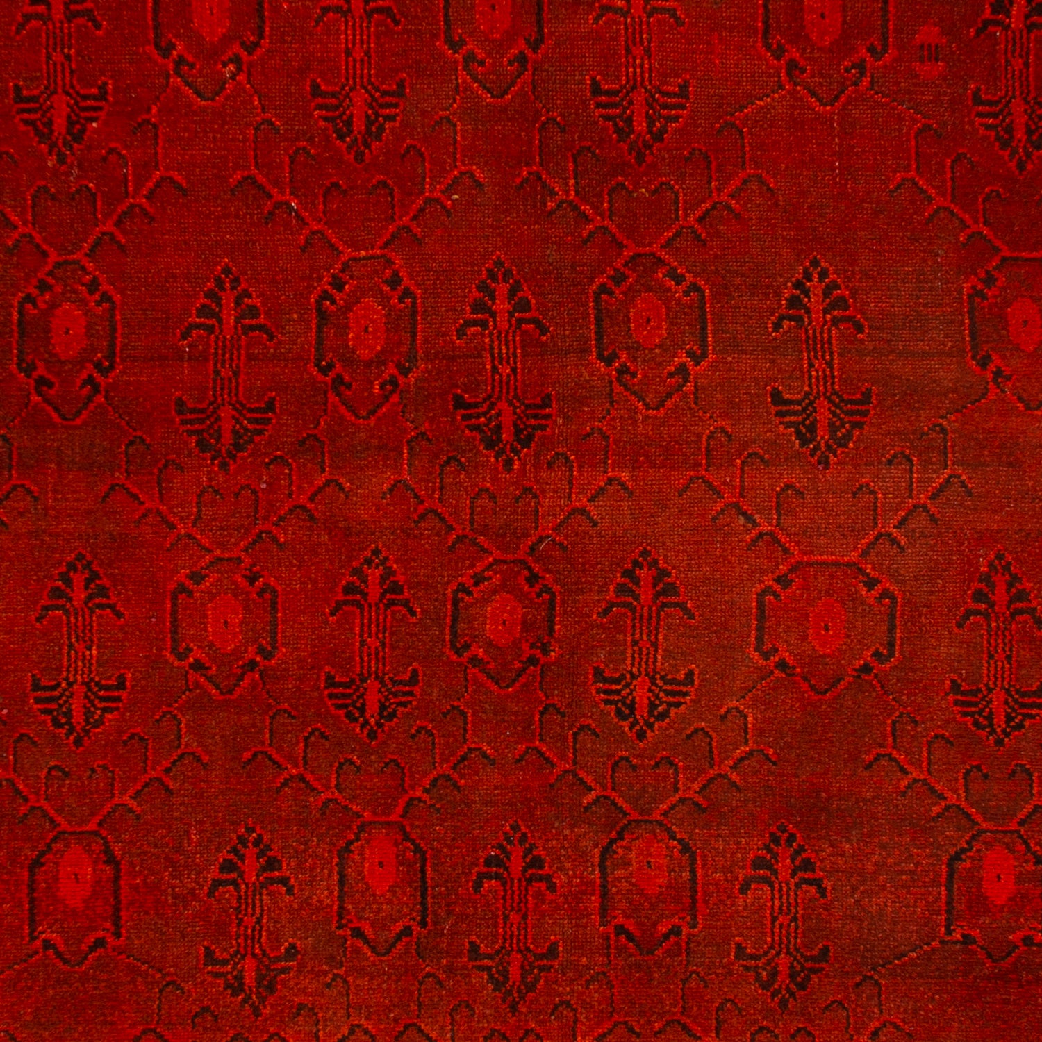 Close-up of rich red fabric with intricate symmetrical pattern.