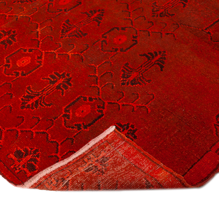 Vibrant red traditional rug with intricate geometric and floral motifs.