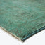 Green rug with fuzzy texture and bound edges on white background.