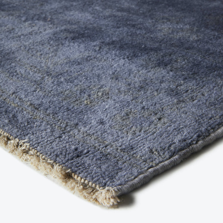 Close-up of a plush blue carpet with intricate fiber detail