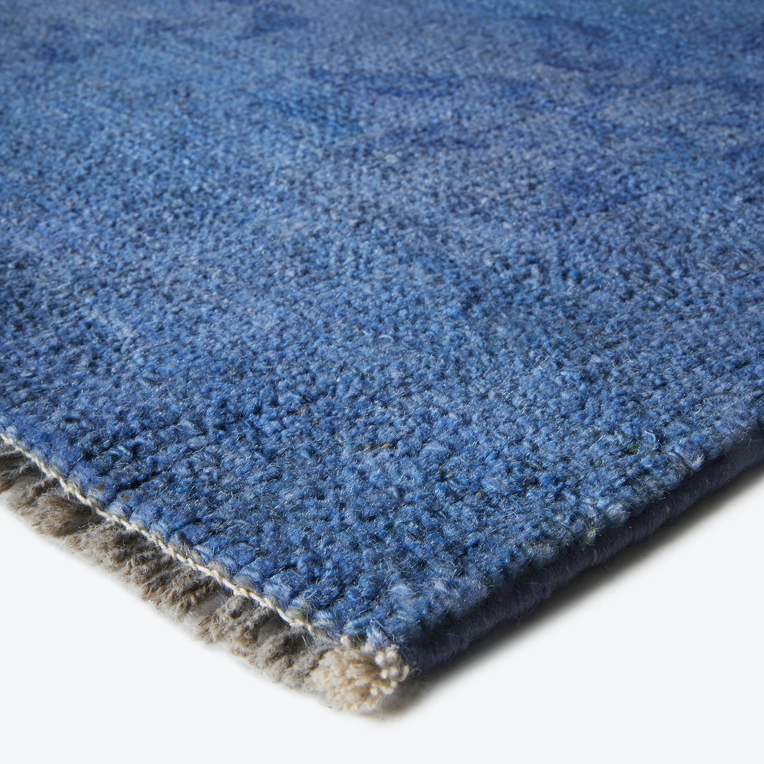Close-up of a plush blue carpet with distinct texture variations.