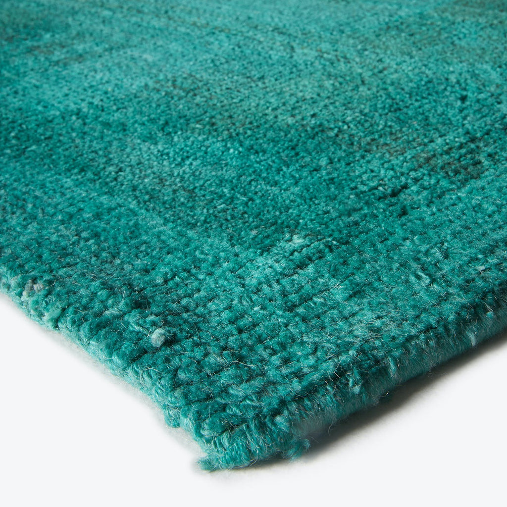 Vibrant teal plush fabric with varying texture and shimmering quality.