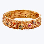 Elegant golden bracelet with textured surface and playful gemstones