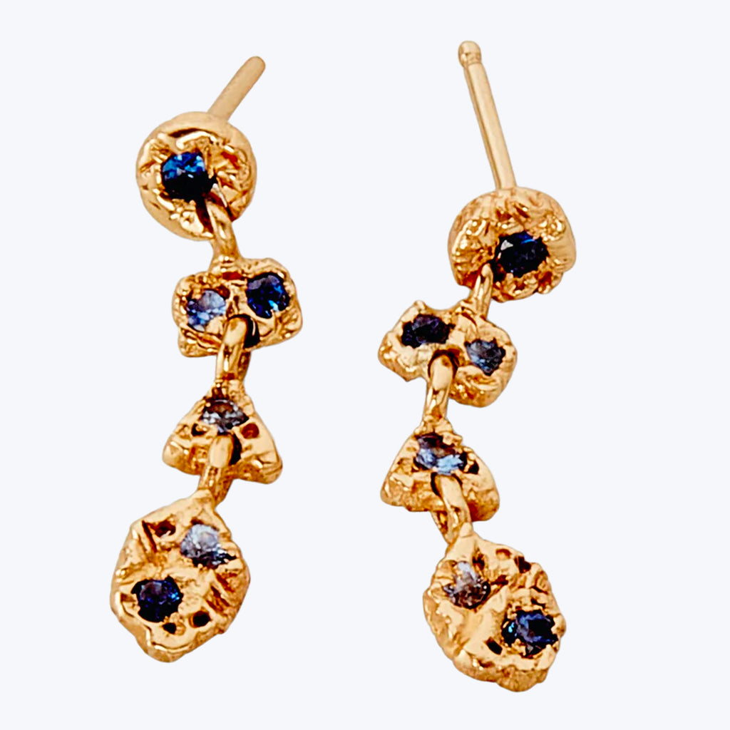 Gold-tone dangle earrings with textured surface and dark gemstones.