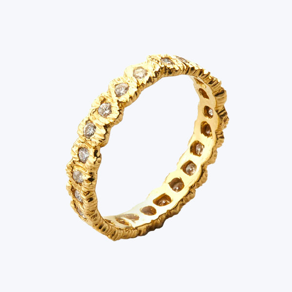 Gold ring with textured band and sparkling gemstone embellishments
