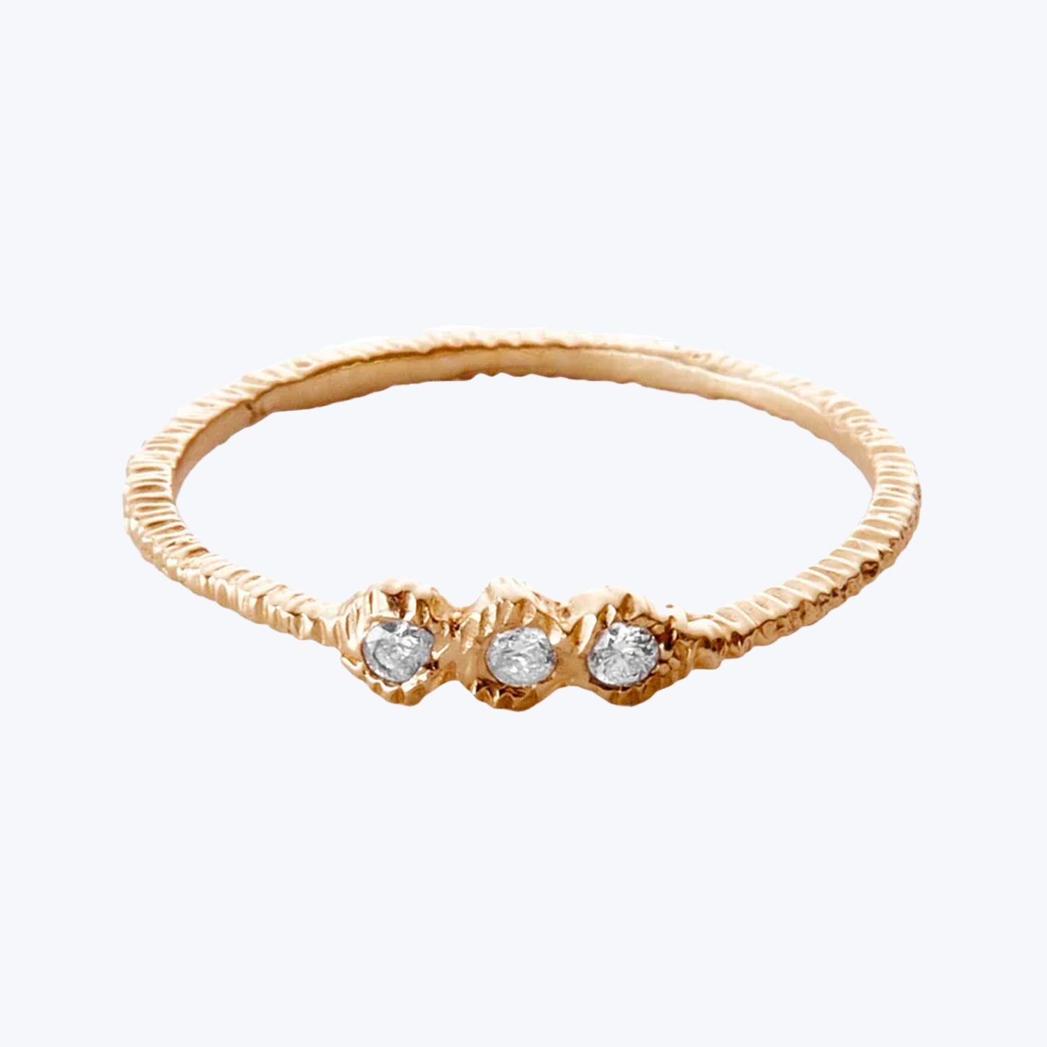 Elegant gold ring with three sparkling round gemstone settings.