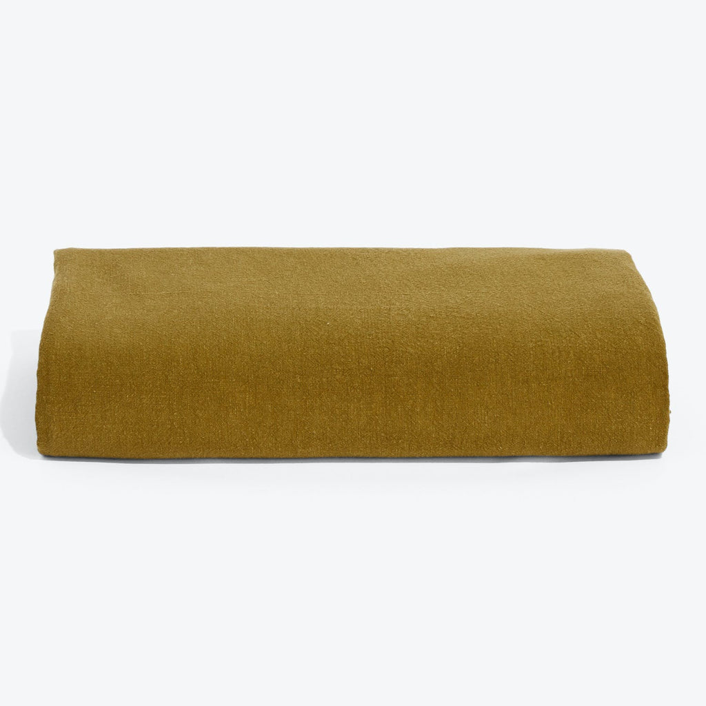 Folded mustard yellow fabric showcasing its smooth texture and flexibility.