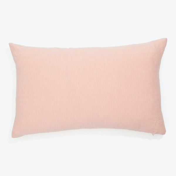 Soft, pale pink rectangular pillow with subtle embossed emblem.