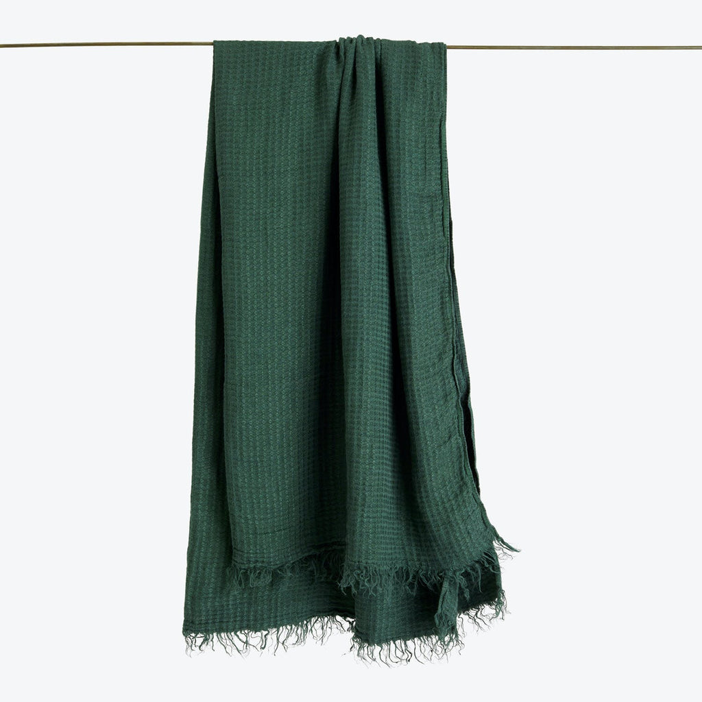Dark green textured fabric hanging over a horizontal line.