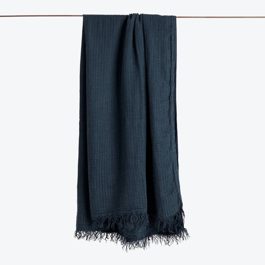 Lightweight dark textile with visible woven texture and fringe detail.