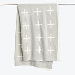 Grey fabric with white plus signs drapes over horizontal rod.